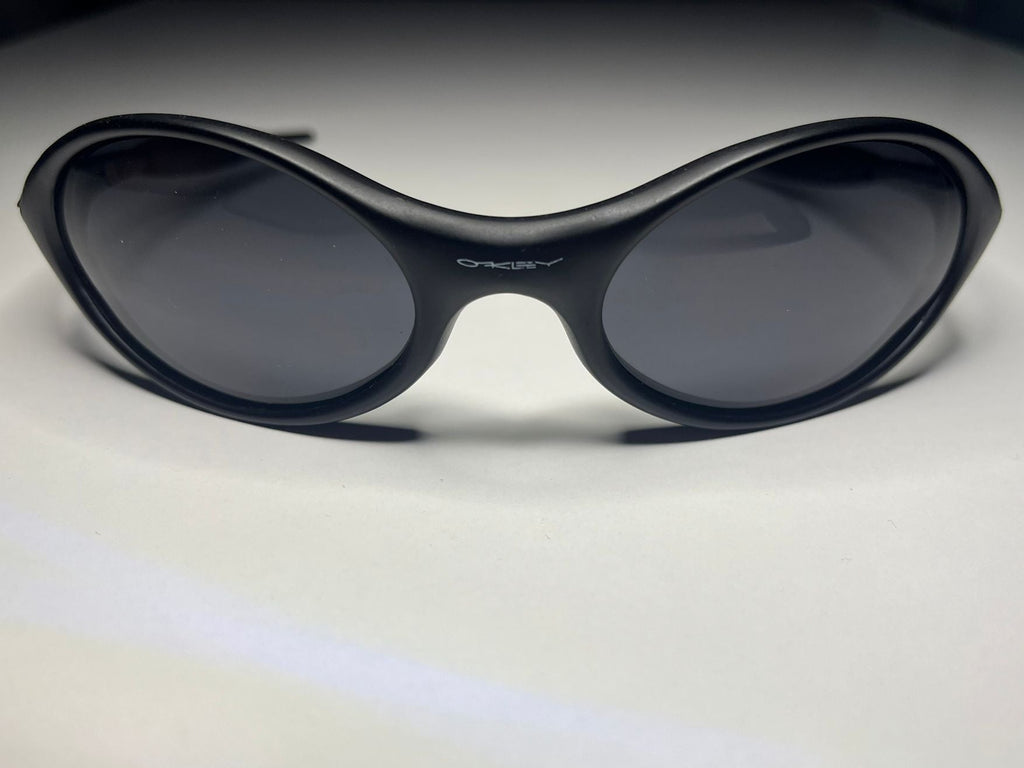 Black sunglasses with dark lenses on a light gray background