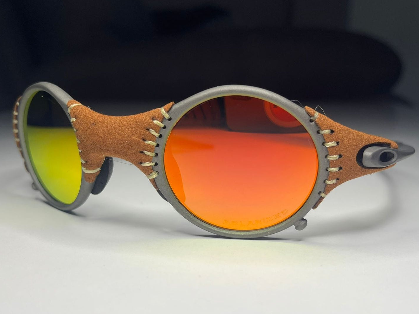 Sunglasses with orange and yellow lenses on a light surface