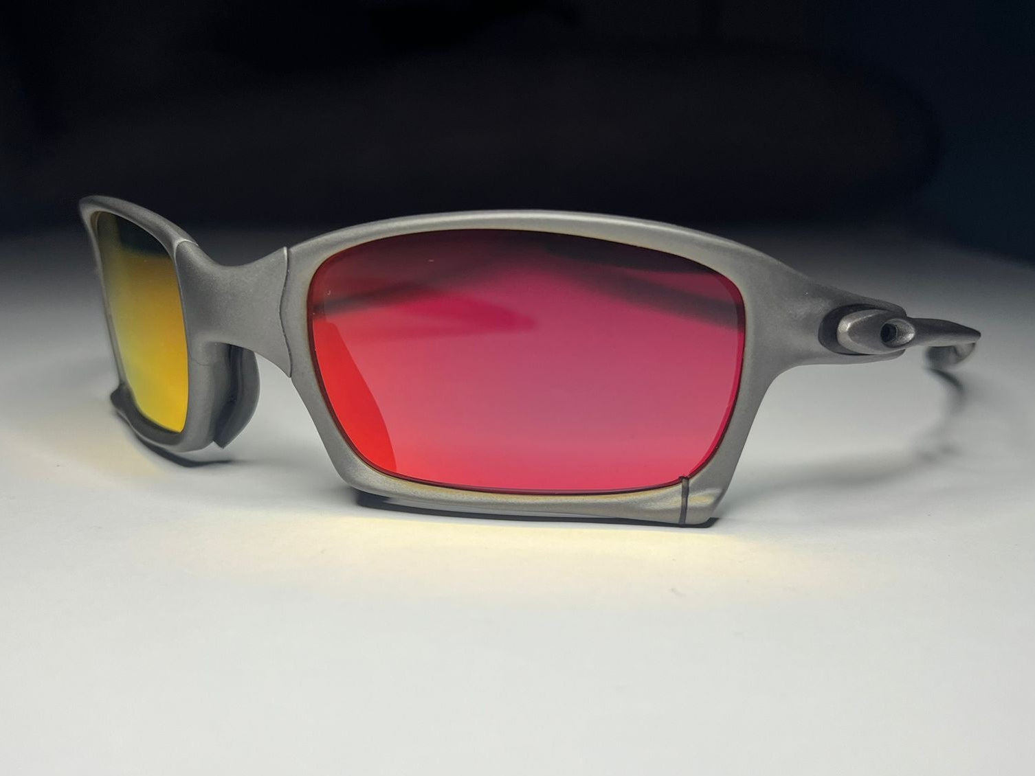 Sunglasses with red lenses and gray frame on a white background