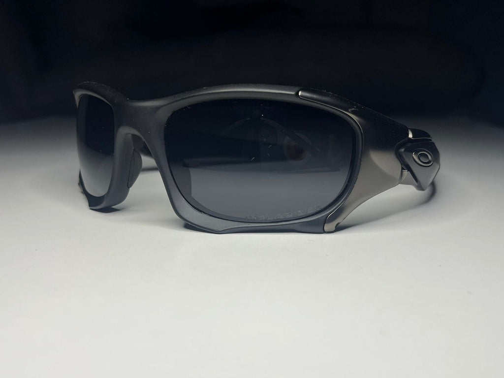 Black sunglasses with dark lenses on a white surface