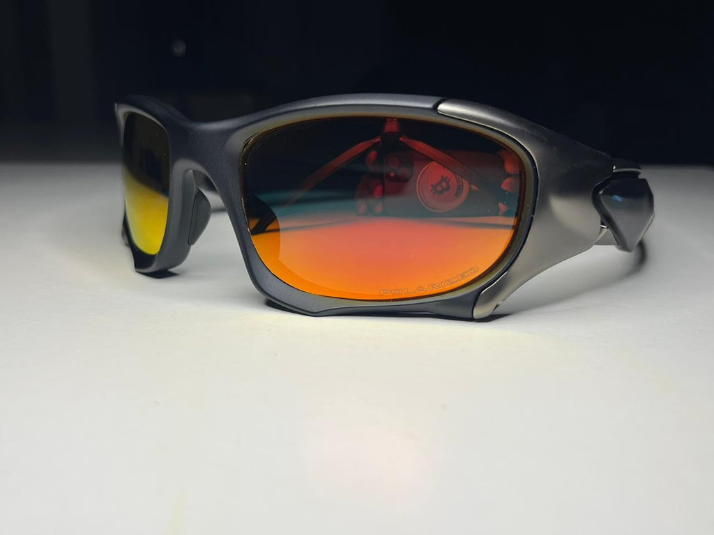 Sunglasses with reflective orange lenses on a white surface