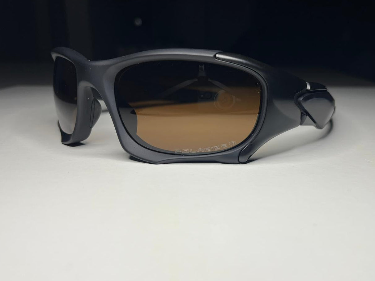 Black sunglasses with brown lenses on a white surface with a black background
