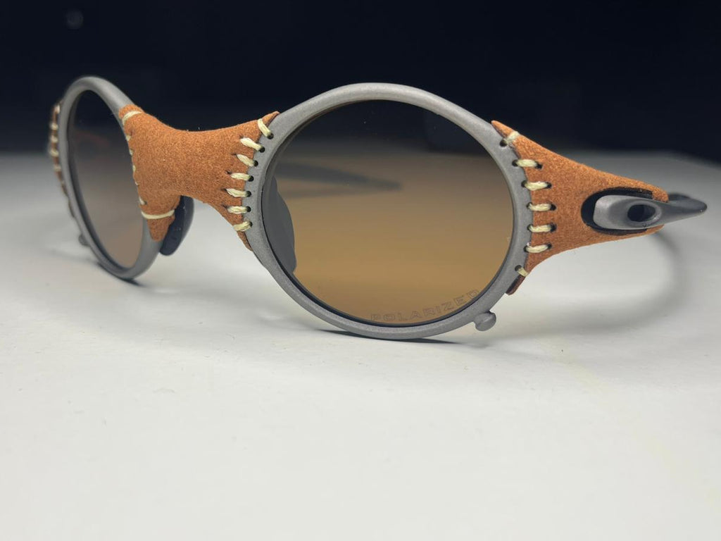 Sunglasses with brown frame and gradient lenses on a light gray background
